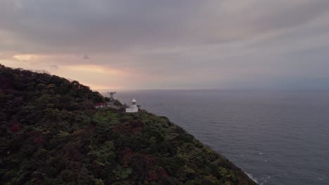 Aerial-sunset-landscape-of-a-cliff-geometrical-to-Japanese-Skyline-in-Kyotango-travel-destination-clouds-moving-at-Kansai,-Japan,-sunset-islands,-sky-at-golden-hour-with-pink-gradients-discovery-shot