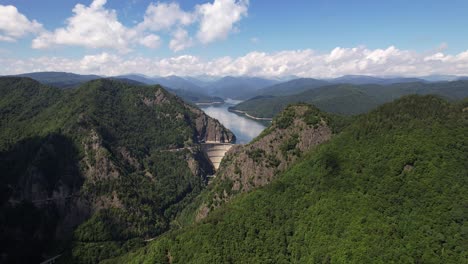 Vidraru-dam-in-the-fagaras-mountains,-a-hydroelectric-marvel-amidst-lush-forests,-aerial-view
