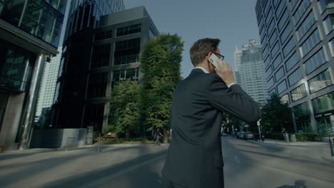 Elegant-young-manager-in-suit-talking-on-phone-in-office-surroundings