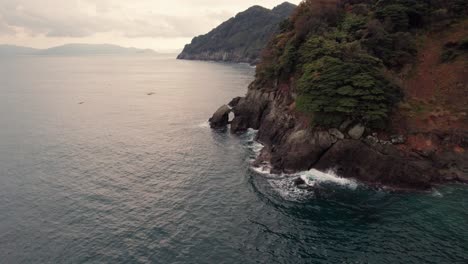 Luftdrohne-Fliegt-über-Die-Halbinsel-Kyotango-In-Japan,-Meer,-Natürliche-Umgebung,-Sommer,-Kansai-Reiseziel,-Berghintergrund,-Blaue-Wellen,-Skyline-Bei-Sonnenuntergang