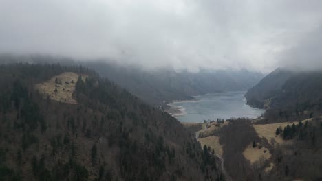 Drohne-Steigt-Auf,-Um-Tief-Im-Bergwald-Einen-Zugefrorenen-See-Oder-Stausee-Zu-Finden