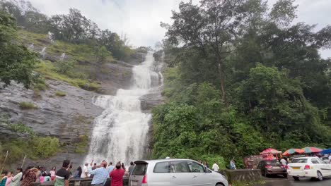 Toma-Pov-Genial-Una-Cascada-Cae-De-Una-Montaña-Mucha-Gente-Está-Mirando-Mucha-Gente-Está-Tomando-Videos-Y-Mucha-Gente-También-Está-Mirando-Estacionando-Las-Cuatro-Ruedas