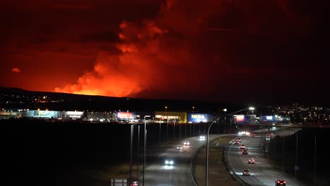 Volcano-Explosion-at-night-behind-mountain-with-rising-fumes