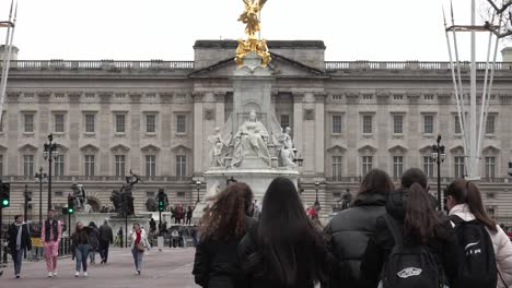 Tourists-pose-for-the-camera-in-front-of-Buckingham-Palace-in-London,-UK