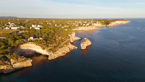 Aerial-View-Of-Rocky-Natural-Arch-Along-Palma-Coastline-During-Golden-Hour-Sunlight