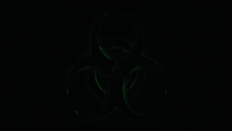 Real-TV-capture:-a-flickering-green-shape-on-black-background,-signaling-a-biohazard-danger-