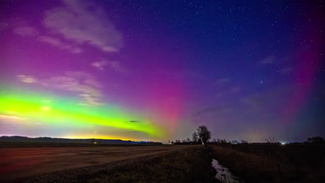 Vivid-solarstorm-with-clouds-moving-over-a-raw-countryside-landscape---Timelapse