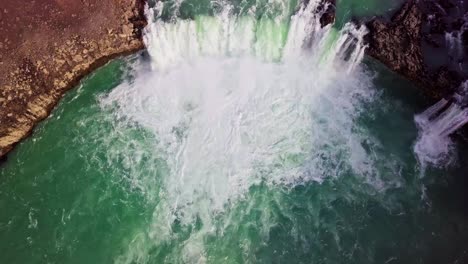 Flyover-gushing-waterfall-and-turquoise-river-rapids-in-Iceland