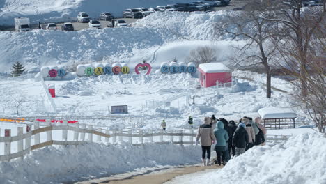 People-walking-down-path-clear-of-snow-at-Daegwallyeong-Sky-Ranch,-Korea