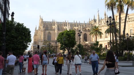People-walking-along-Constitution-Avenue-at-sunset,-Seville,-Spain