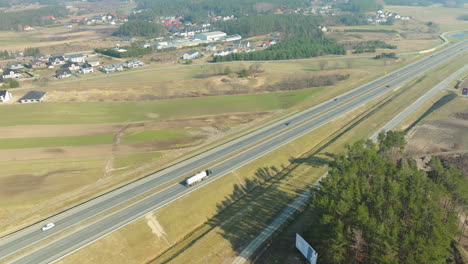 Aerial-view-of-highway-amidst-rural-landscape-and-vehicles