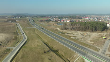 Aerial-perspective-of-a-highway-near-a-rural-town-with-construction-in-the-vicinity