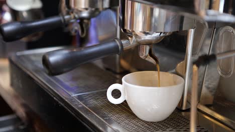 Handaufnahmen-Einer-Kaffeemaschine,-Bei-Der-Kaffee-In-Eine-Tasse-Gegossen-Wird