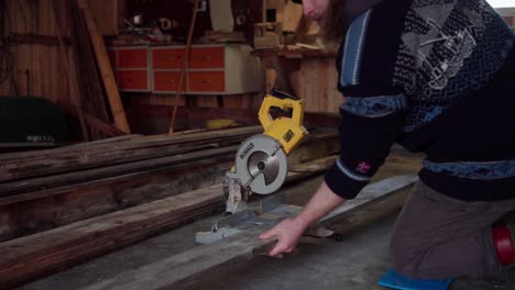 A-Man-Crouches-to-Use-a-Circular-Saw-in-Cutting-the-Wooden-Plank-for-the-Cladding-of-the-Hot-Tub---Close-Up