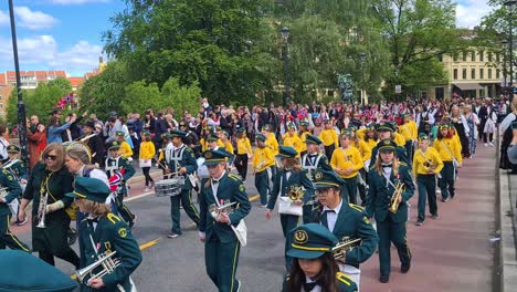 Street-Parade-During-Constitution-Day-in-Downtown-Oslo,-Norway,-Marching-Band-and-Kids-in-Uniforms