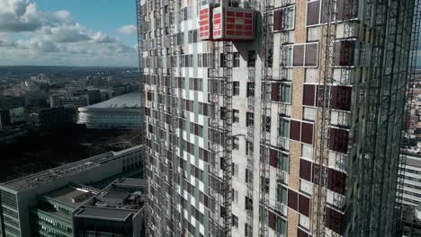 Construction-elevators-ascending-and-descending-on-exterior-wall-of-skyscraper,-La-Defense,-Paris-in-France