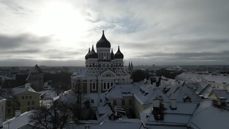 Aerial-view-of-the-churches-in-the-Old-Town-of-Tallinn,-Estonia-in-winter-tilt-up-angle