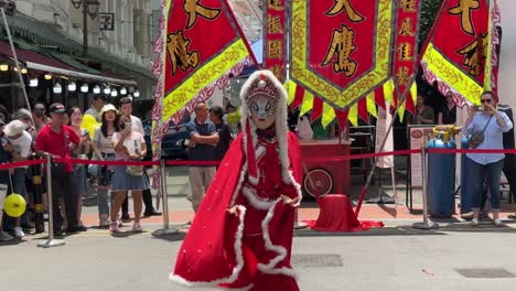 Face-or-mask-changing-street-performer-dancing-around-and-performing-in-Chinatown,-Singapore