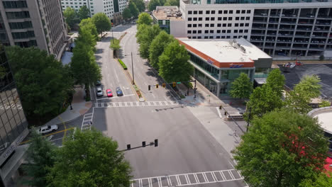 Toma-Aérea-A-Vista-De-Pájaro-Del-Distrito-De-Oficinas-En-Atlanta-Con-Autos-En-El-Cruce-A-La-Luz-Del-Sol