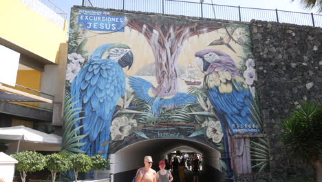 Tourists-walking-under-a-colourful-bridge-tunnel-from-Las-Americas-to-Los-Christianos-in-Tenerife