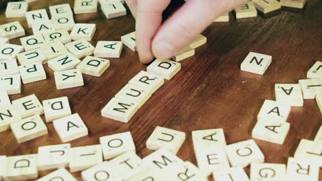 Bright-Scrabble-tile-letters-flip-over-to-form-word-MURDER-on-table