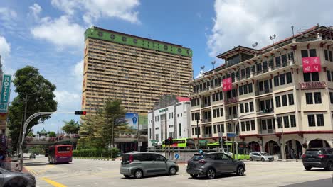 Point-of-view-of-the-street-scene-and-moving-vehicles,-and-against-the-background-of-the-famous-People's-Park-Complex-Condo-and-Yue-Hwa-Mall-in-Chinatown-Singapore