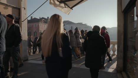 Bulliciosa-Multitud-Paseando-Por-Las-Tiendas-Venecianas-Al-Atardecer,-En-La-Cima-Del-Puente-De-Rialto