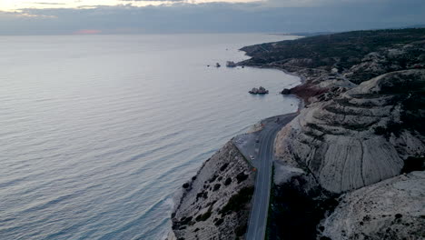 Die-Küstenstraße-Schlängelt-Sich-Entlang-Der-Zypriotischen-Klippen-Und-Bietet-Einen-Weiten-Blick-Auf-Das-Mittelmeer-Im-Sanften-Morgenlicht.-Die-Küstenlinie-Ist-Von-Geologischen-Formationen-Geprägt