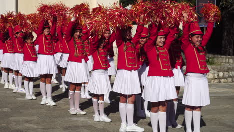 Young-Majorette-Girls-With-Pom-Poms-in-Red-Uniforms-at-Festival