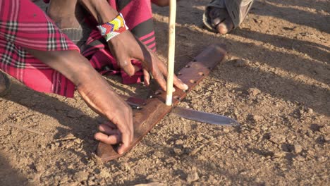 Primer-Plano-De-Gente-Masai-Local-Haciendo-Fuego-Por-Fricción-Con-Palos-De-Madera-En-El-área-De-Masai-Mara-En-Kenia,-África