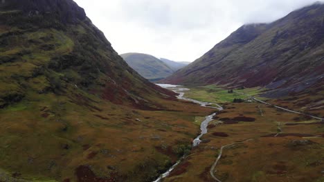 Luftaufnahme-Der-Dramatischen-Glencoe-Landschaft-In-Schottland-Mit-Dem-Fluss-Coe,-Der-In-Der-Mitte-Fließt