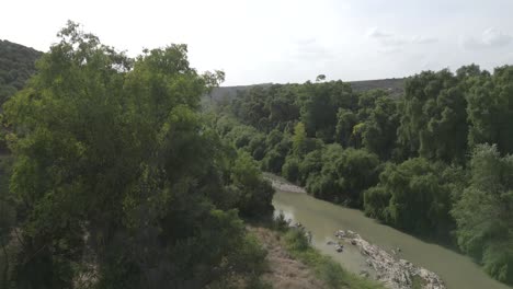 A-panning-aerial-shot-over-the-Guadalquivir-River-in-Marmolejo,-Jaén-province,-Spain,-showcasing-its-natural-beauty-and-lush-landscapes