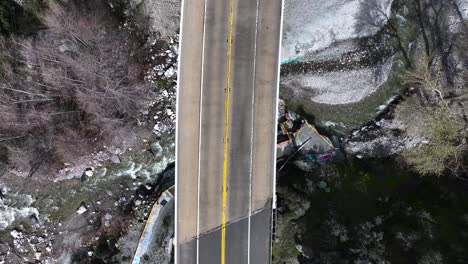 descending-on-California-Highway-38-to-Forest-Falls-top-down-shot-and-a-bridge-with-a-waterfall-underneath-60FPS-SLO-MO