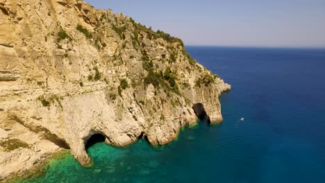 Drone-panning-in-front-of-the-rocky-cliffs-of-Oasi,-a-secluded-breathtaking-getaway-located-near-the-village-of-Chania,-in-the-island-of-Crete-in-Greece