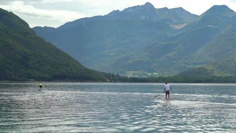 Zwei-Junge-Franzosen-Schwimmen-An-Einem-Bewölkten-Tag-Auf-Einem-Standup-Paddleboard-über-Den-See-Von-Annecy