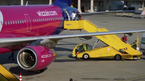 People-disembarking-from-Wizzair-Airbus-A321-aircraft-at-Vienna-International-Airport-using-boarding-stairs