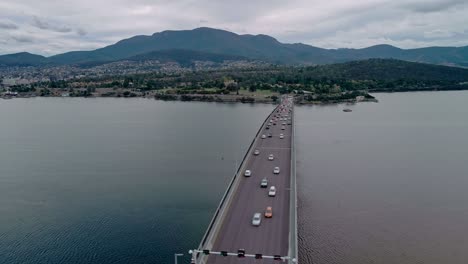 Parallax-drone-shot-of-bridge-with-vehicles-running-on-it-over-a-river