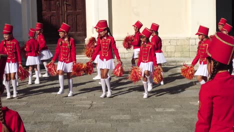 Majoretten-Mädchen-In-Roten-Uniformen-Und-Pompons,-Choreographie-Probe-Für-Das-Festival