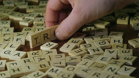Close-up-Scrabble-tile-letters-make-word-TRUTH-by-man's-right-hand