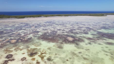 Aerial-forward-ascending-shot-over-Los-Roques'-shallow-waters-revealing-protected-wetlands