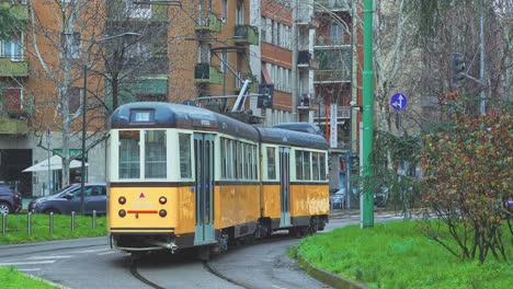 Die-Weiße-Und-Gelbe-Elektrische-Straßenbahn-Gleitet-Sanft-über-Die-Gleise-Der-Stadt-Mailand