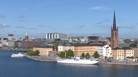 Stockholm-Altstadt-Gesamtansicht-Mit-Einigen-Schiffen,-Dem-Hafen-Und-Dem-Riddarholmen-Kirchturm