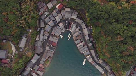 Aerial-drone-top-down-boat-houses-in-japanese-green-cliff-beach-Kyoto-Kyotango-travel-destination,-blue-sea,-traditional-architecture,-asian-natural-environment-kyoto-by-the-sea