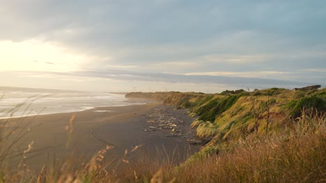 Colorful-sunset-over-an-empty-beach-in-New-Zealand-on-a-windy-day