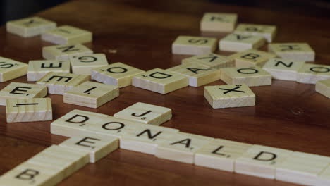 Close-up-narrow-focus:-Scrabble-tile-letters-form-words-JOE-and-DONALD