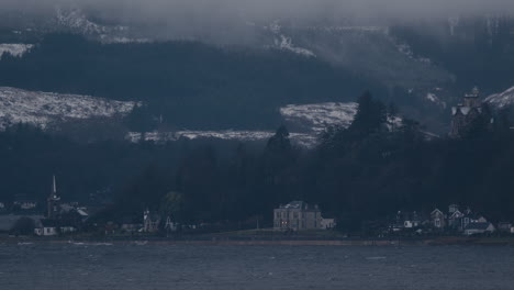 Entfernte-Stadt,-Haus-Und-Kirche-Am-Meer-Mit-Schneebedeckten-Bergen-Im-Hintergrund