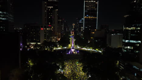 Aerial-view-approaching-the-illuminated-El-Ángel-statue,-night-in-Mexico-city