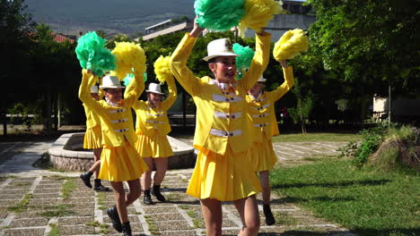 Grupo-De-Jóvenes-Majorettes-Con-Uniformes-Amarillos-Realizando-Coreografías-Con-Pompones