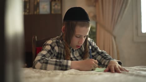 A-jewish-12-year-old-boy-is-sitting-by-a-table-and-writing,-reval-shot