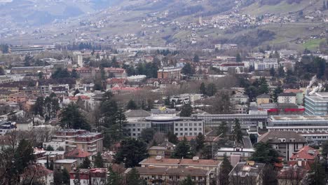 A-yellow-rescue-helicopter-is-departing-from-a-helipad-at-the-top-of-the-hospital-of-Meran-Merano,-South-Tyrol,-Italy